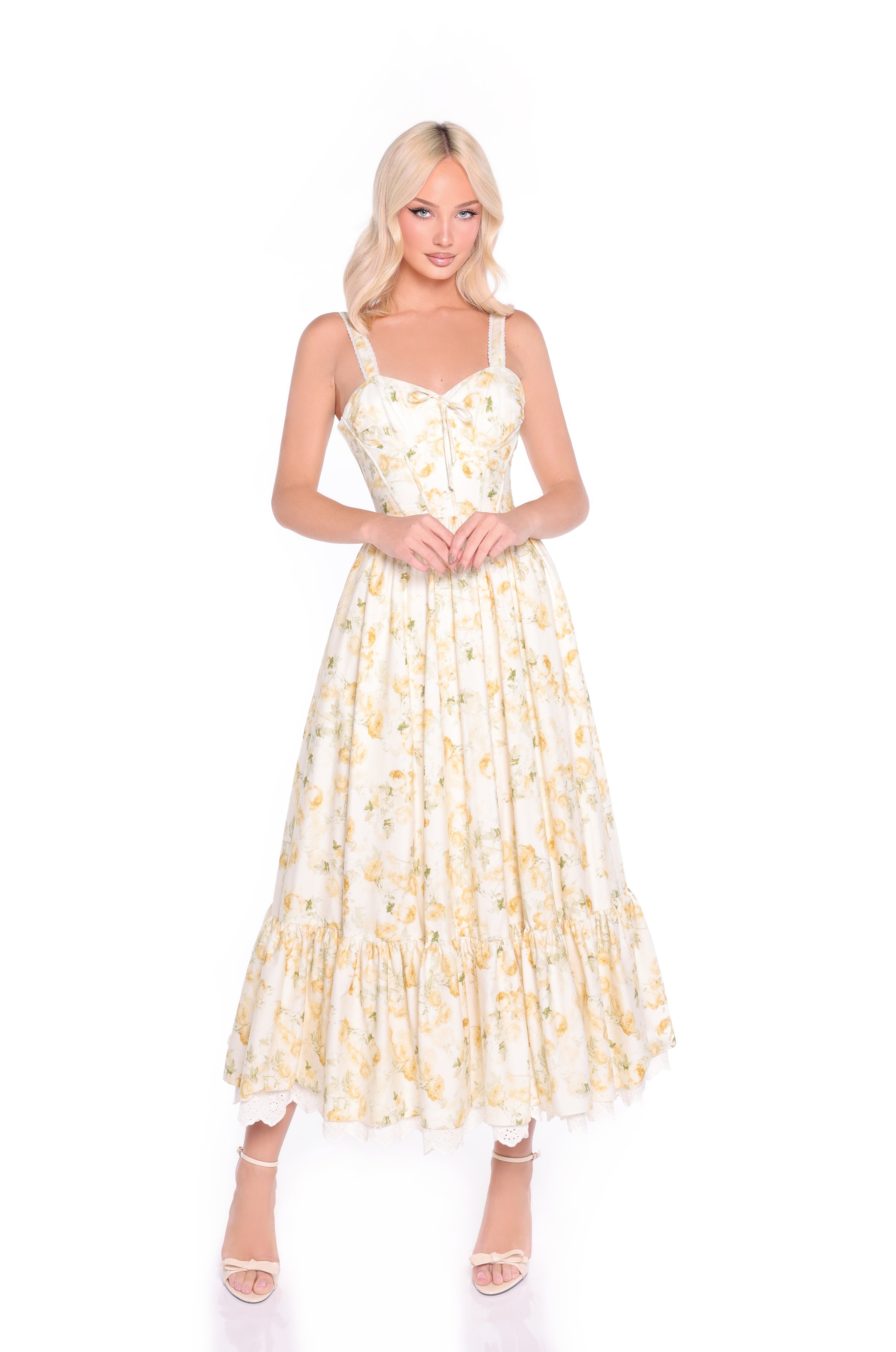 A woman wears the Buttercream Floral Casual Midi Dress: Marigold—featuring a light yellow floral print, corset bodice, and flared midi skirt—while standing against a white background.
